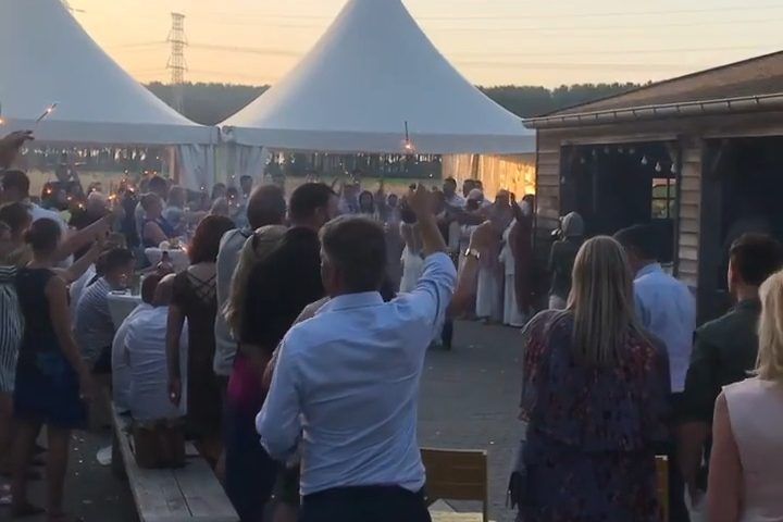Bruiloftsgasten dansen bij de feesttenten in de avondzon